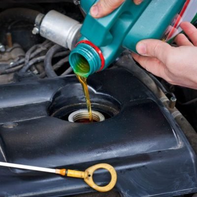 Fresh engine oil being poured into a car engine at Auto Car Repair Dubai