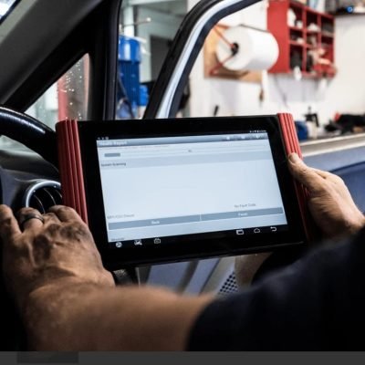 Technician running professional AC diagnostic and pressure test on a vehicle