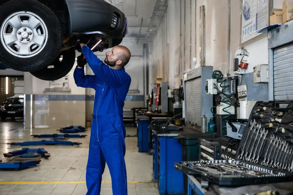Certified technician inspecting car suspension components on a four-post lift at Auto Car Repair Dubai