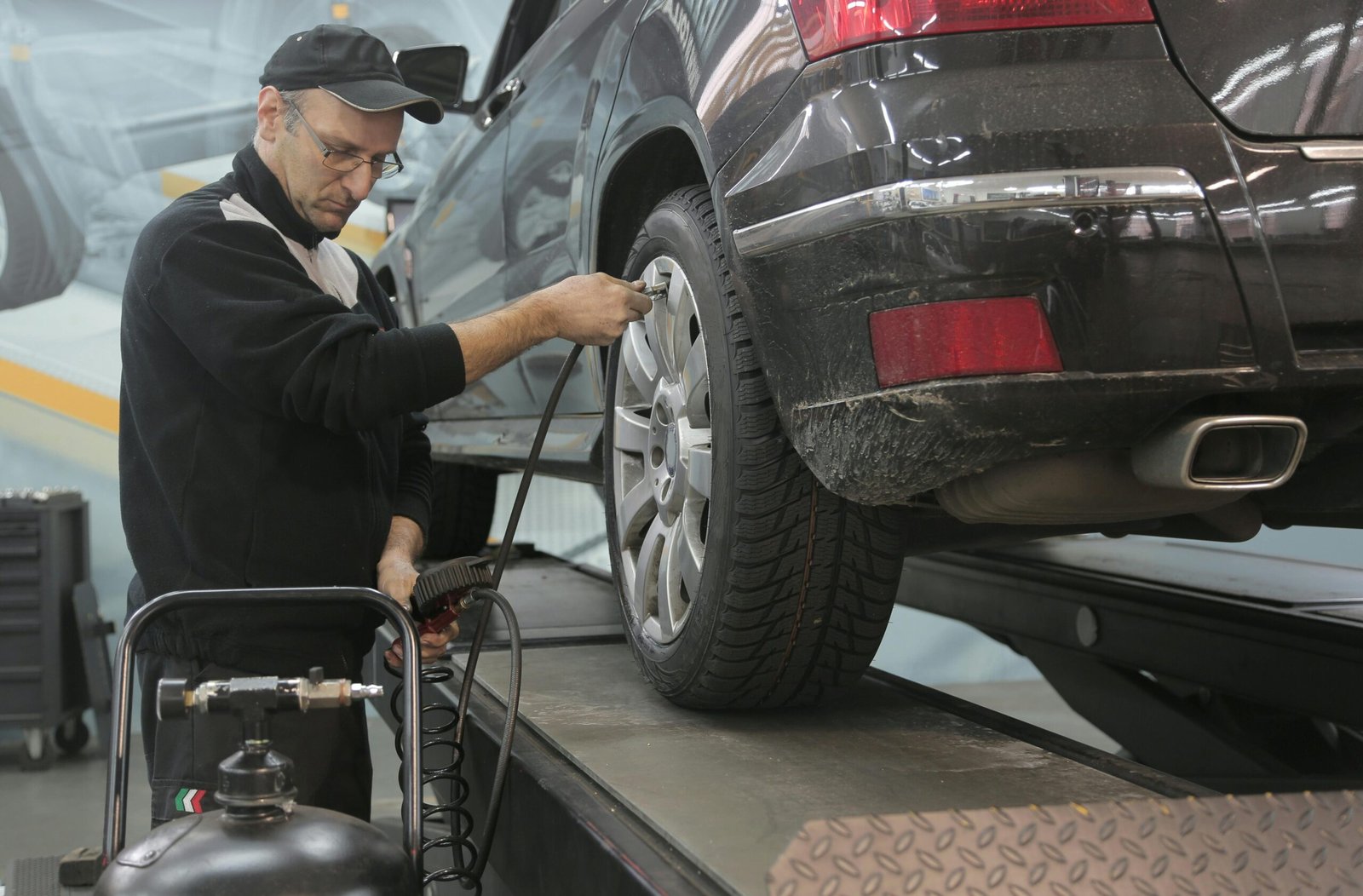 Technician fitting a new tyre to an alloy wheel at Auto Car Repair Dubai workshop